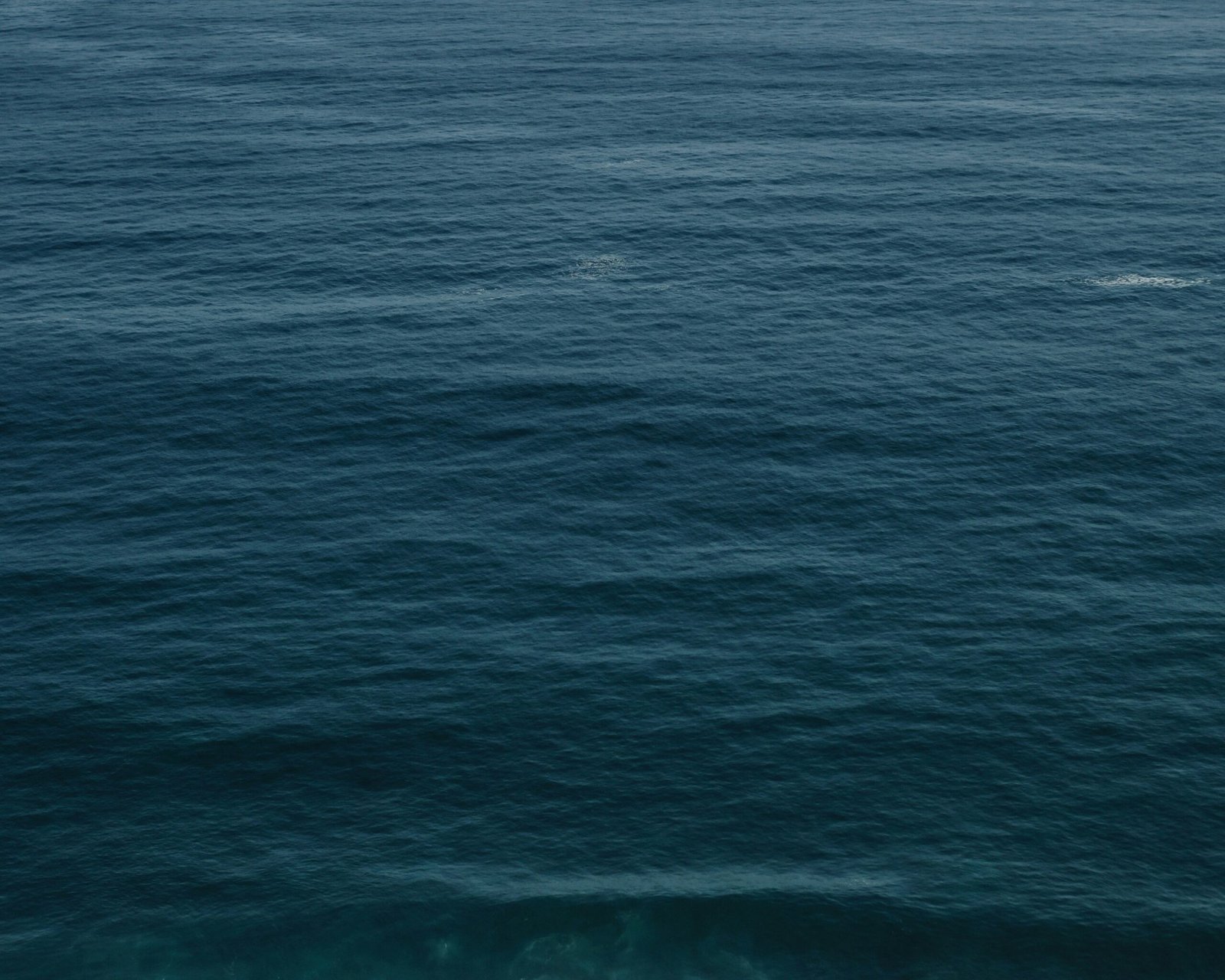 a large body of water with a boat in the distance